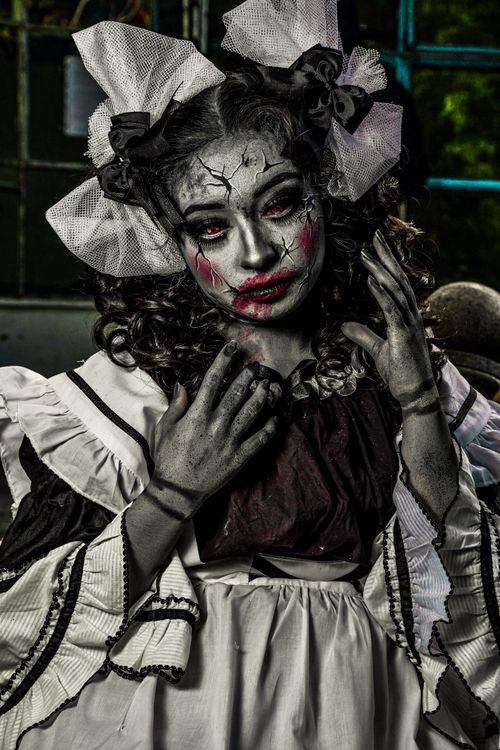 Free A haunting portrait of a person in intricate zombie doll makeup and costume. Stock Photo