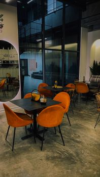 Stylish modern cafe interior featuring bold orange chairs and industrial design elements.