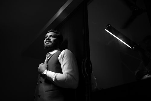 Free Black and white portrait of a groom in a formal suit reflecting elegance and confidence. Stock Photo