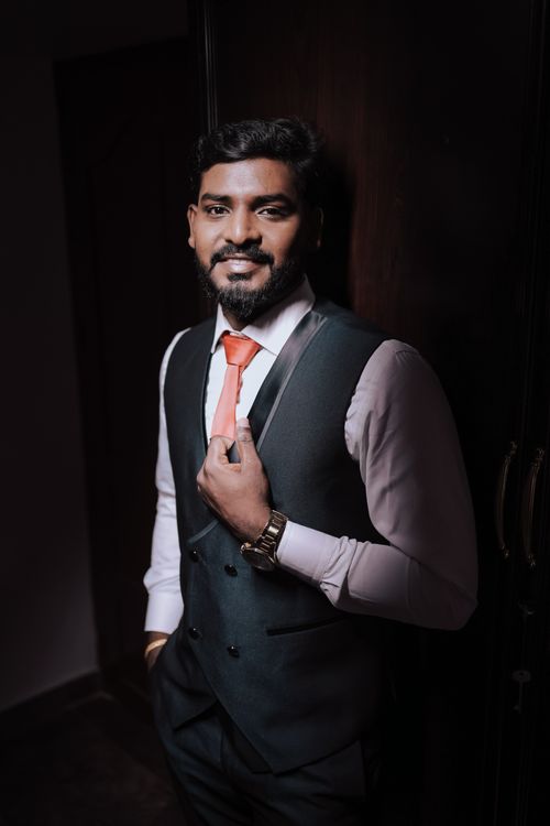 Free Handsome groom standing indoors in a stylish suit, exuding confidence and elegance. Stock Photo