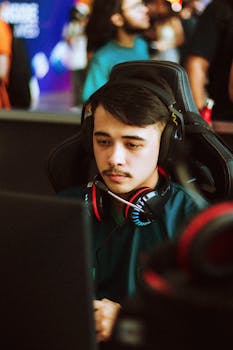 Young male gamer intensely focused at an esports tournament, wearing headphones.