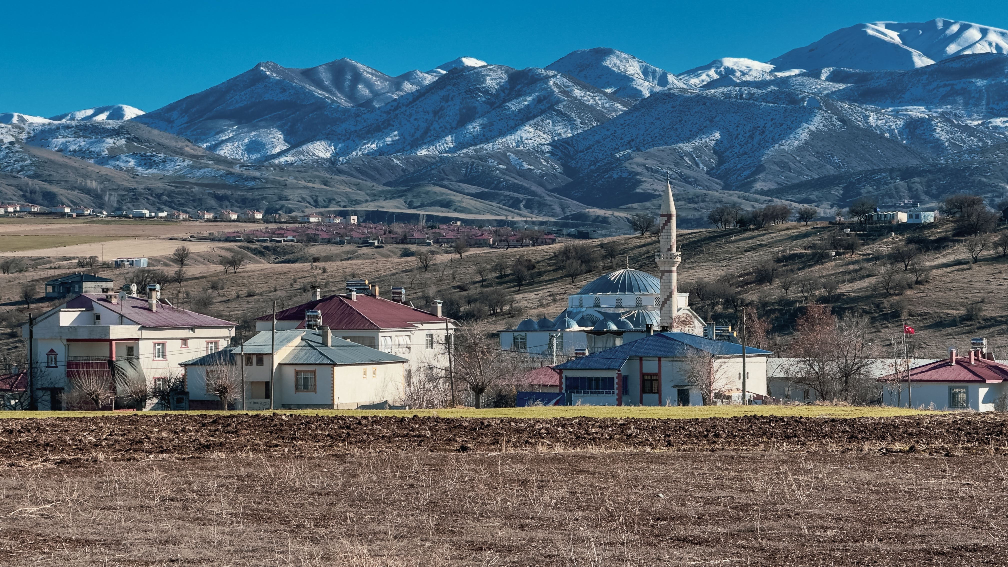 Charming townscape of Kovancılar, Elazığ with snow-covered mountains in the backdrop.