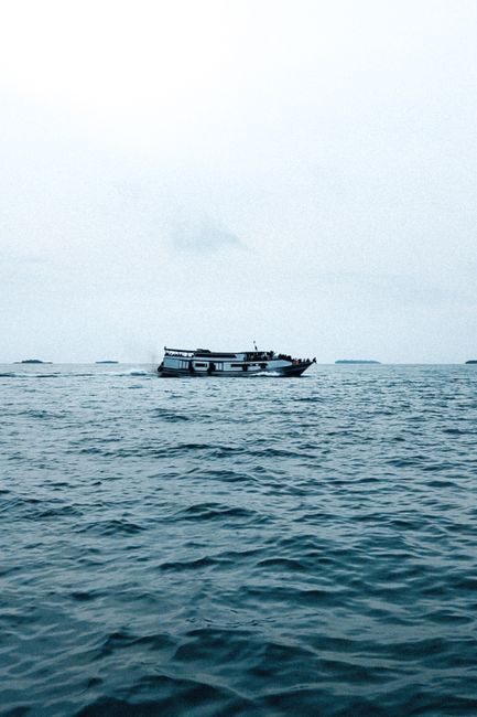 A serene view of a traditional fishing boat on the calm sea in Indonesia, capturing tranquility and adventure.