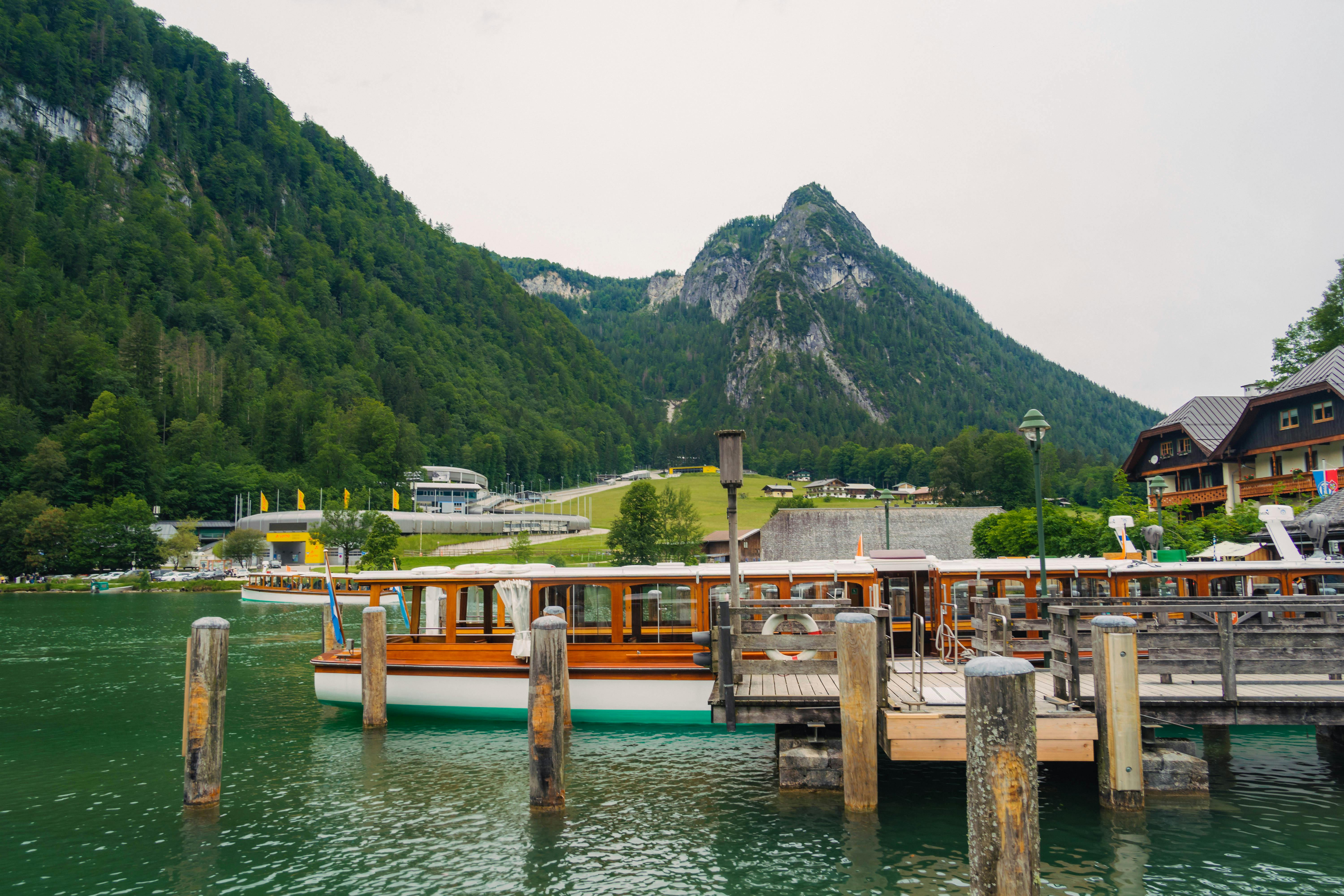 Bờ hồ ở Schönau am Königssee, Bavaria, với thuyền và núi.