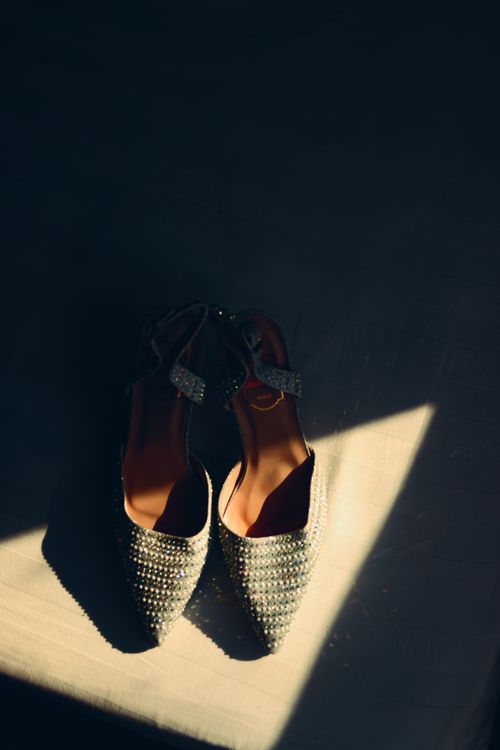 Free Pair of sparkling shoes captured in a dramatic light, highlighting elegance and style. Stock Photo