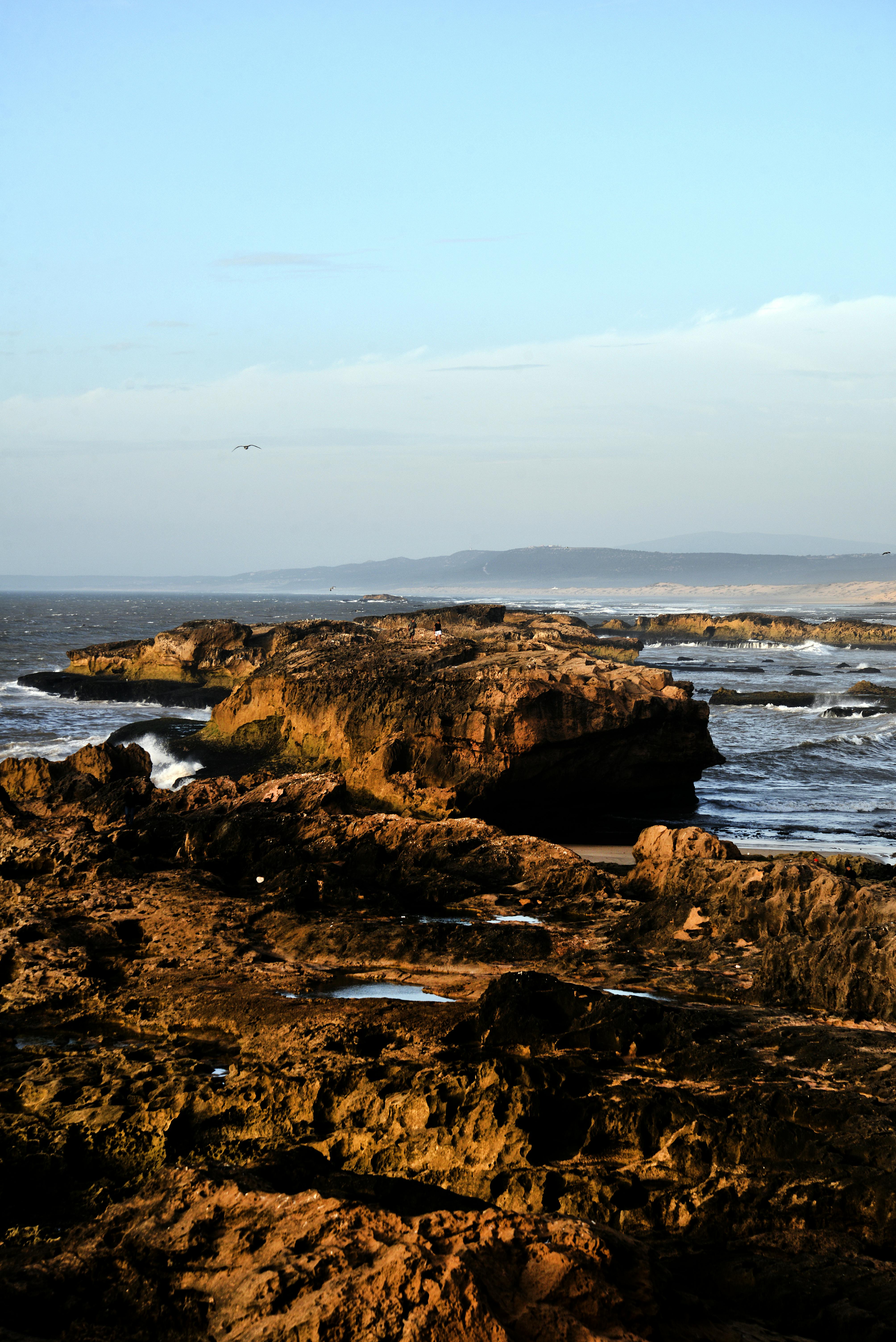 Captivating view of Essaouira's rocky coastline at sunset, highlighting natural beauty and tranquil seascape.