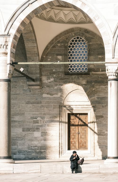 Free A solitary monk meditates under a historic archway, basking in peaceful solitude. Stock Photo