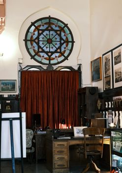 Classic vintage office setup with a decorative stained glass window and wooden furniture.