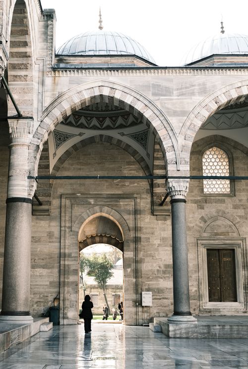 Free A serene view of a historic mosque courtyard with impressive arches and domes. Stock Photo