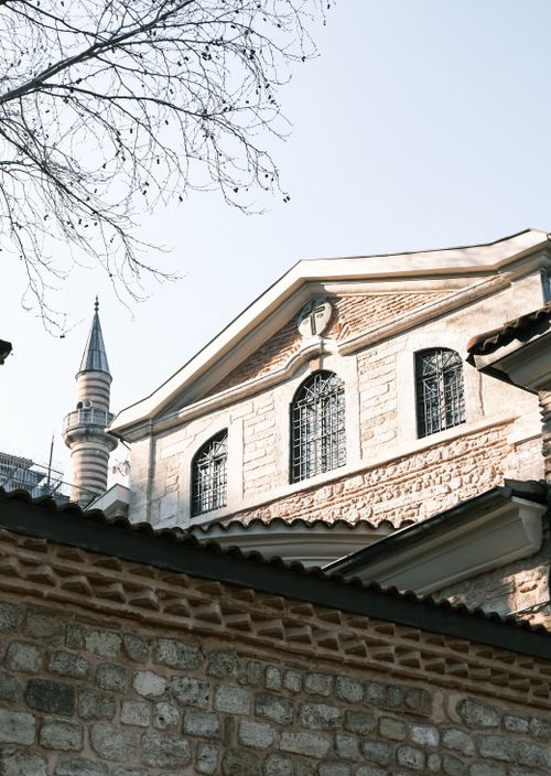 Free A beautiful mosque with an ornate minaret and classic stone architecture under a clear sky. Stock Photo