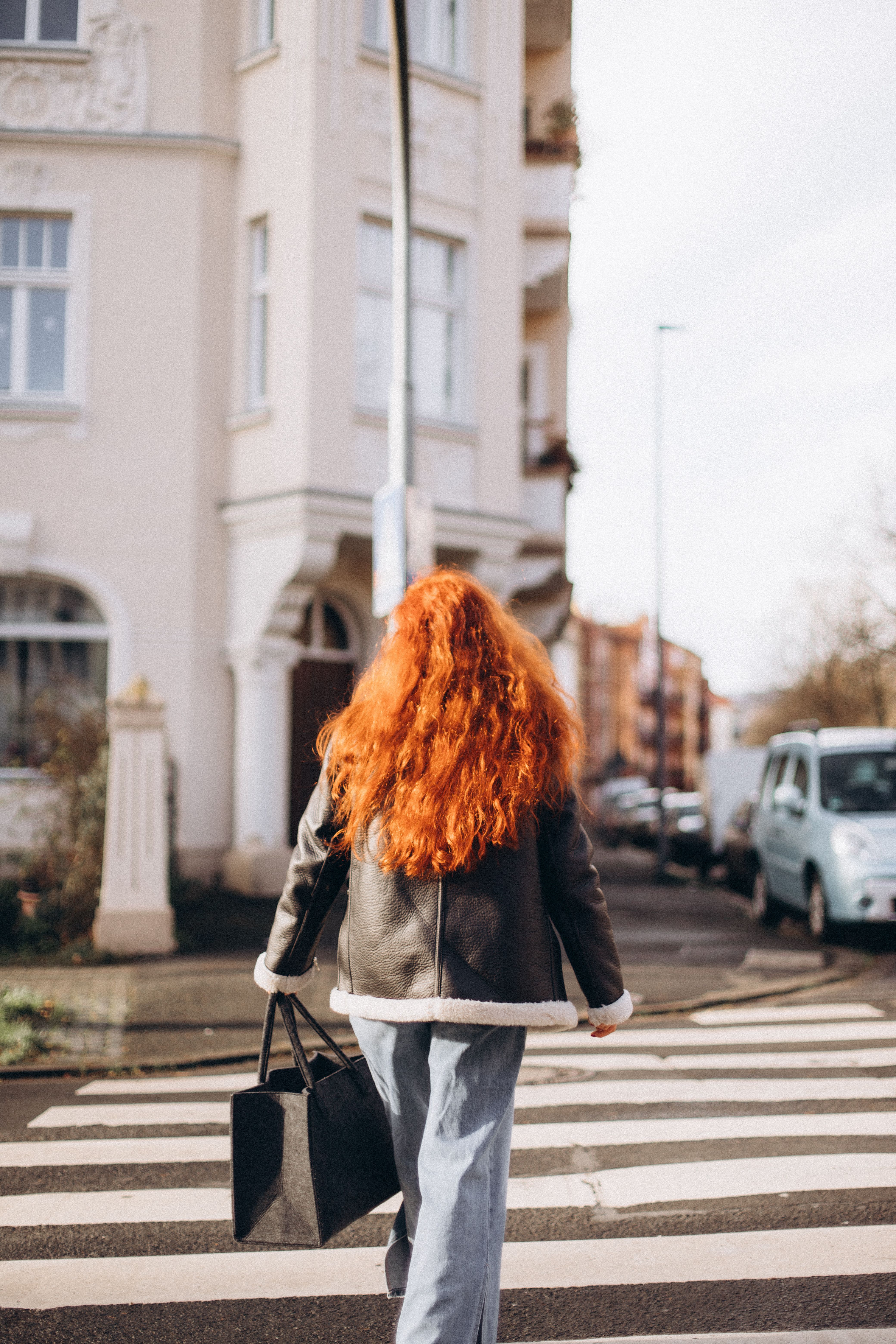 Mujer Cruzando La Calle En Un Barrio Urbano · Foto de stock gratuita