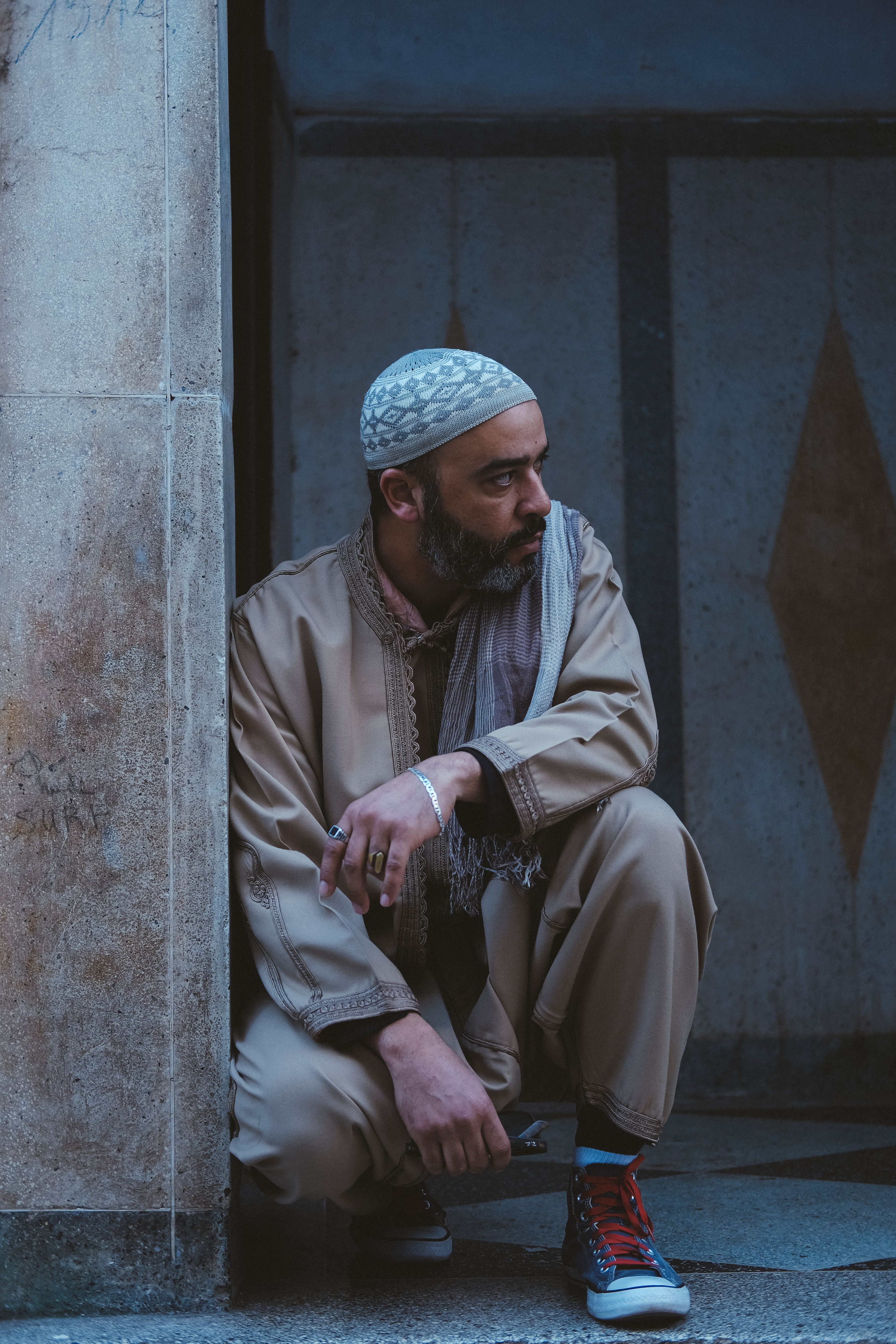 Man in traditional Moroccan clothing sits thoughtfully in Rabat. Moody atmosphere captured.