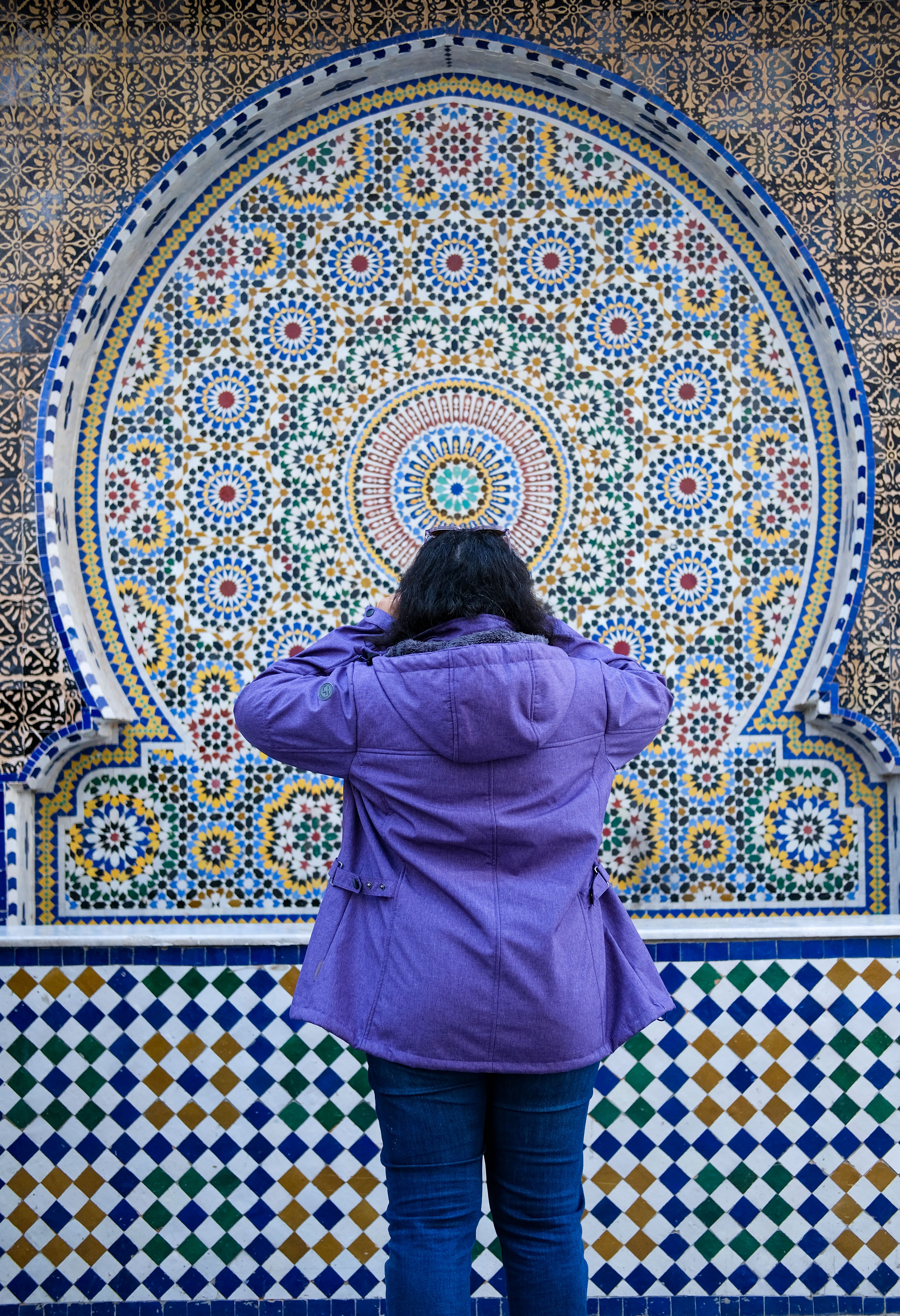 A person stands in front of intricate Moroccan tiles in Rabat, Morocco.