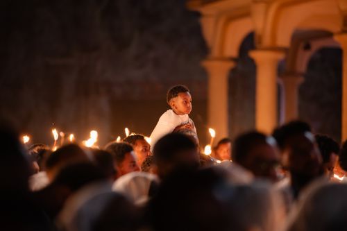 Free A boy on shoulders during a candlelit service at an Ethiopian church. Stock Photo