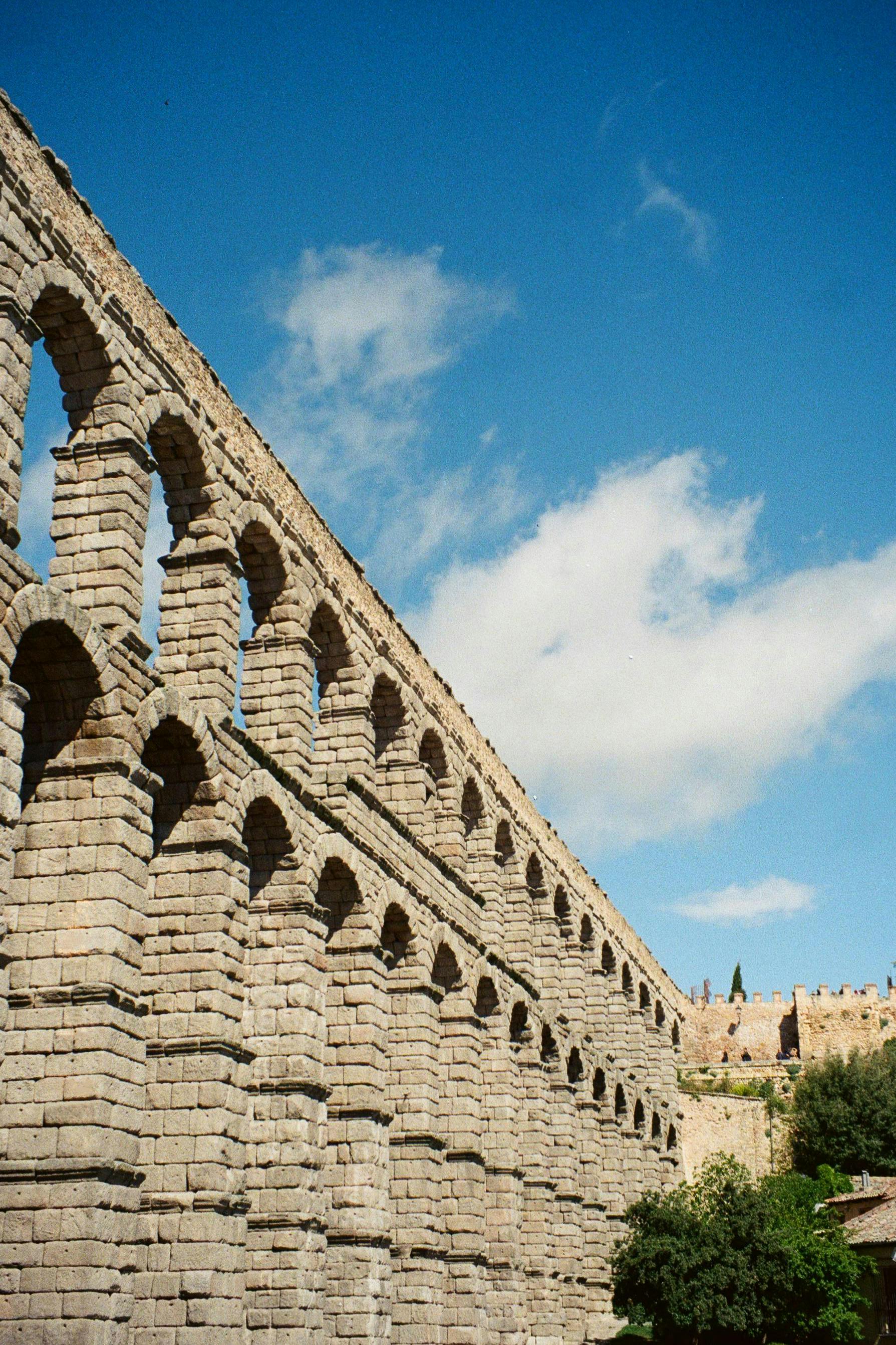 Capture of the ancient Roman aqueduct in Segovia, Spain against a clear blue sky.