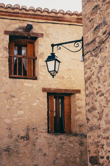 Charming rustic street scene in Okzitanien, France, featuring a vintage lamp and stone architecture.