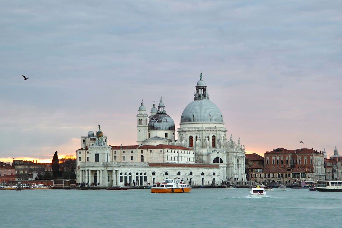 Free View of Santa Maria della Salute with boats on Venice waters at sunset. Stock Photo