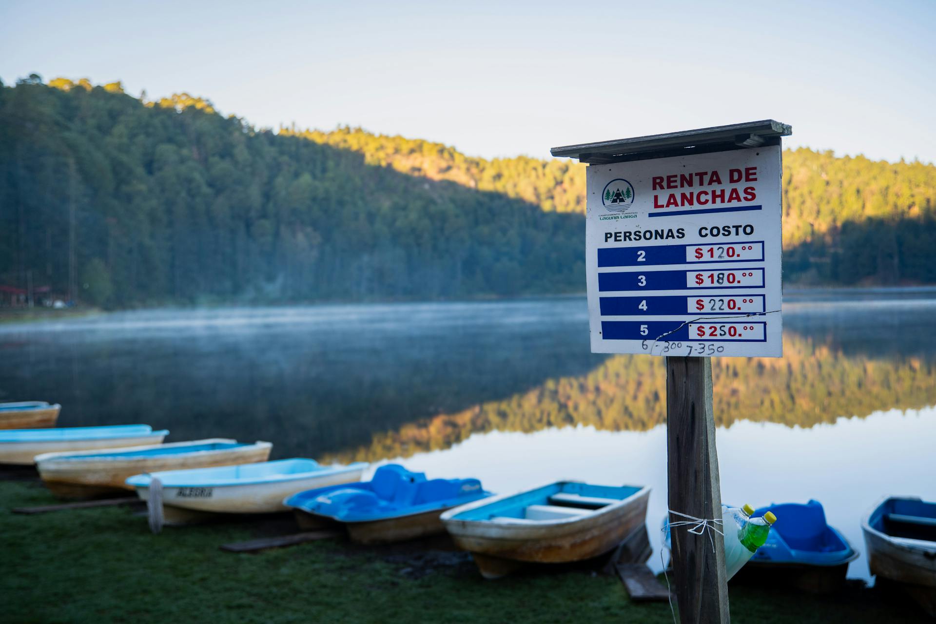 Boat rental sign and serene lake scene at dawn in Los Azufres, Michoacán, México.