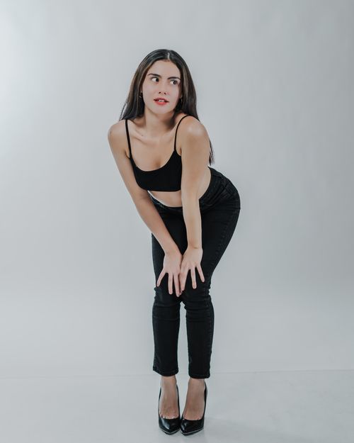 Free Portrait of a confident woman posing elegantly in a stylish black outfit. Stock Photo