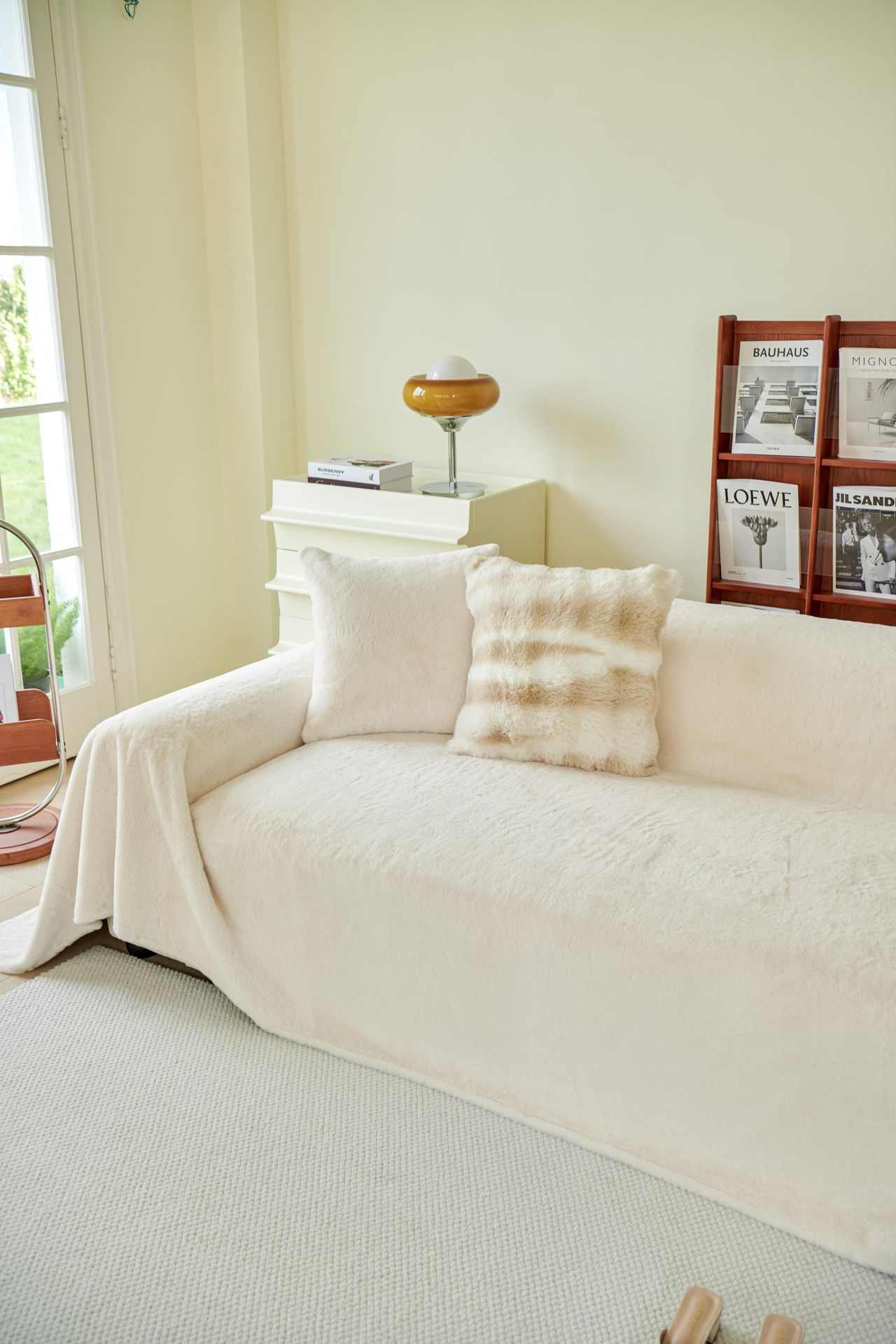Cream sofa beside a warm amber glass table lamp