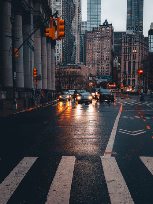 Free A rainy nighttime scene of a busy city street with cars and bright traffic lights. Stock Photo