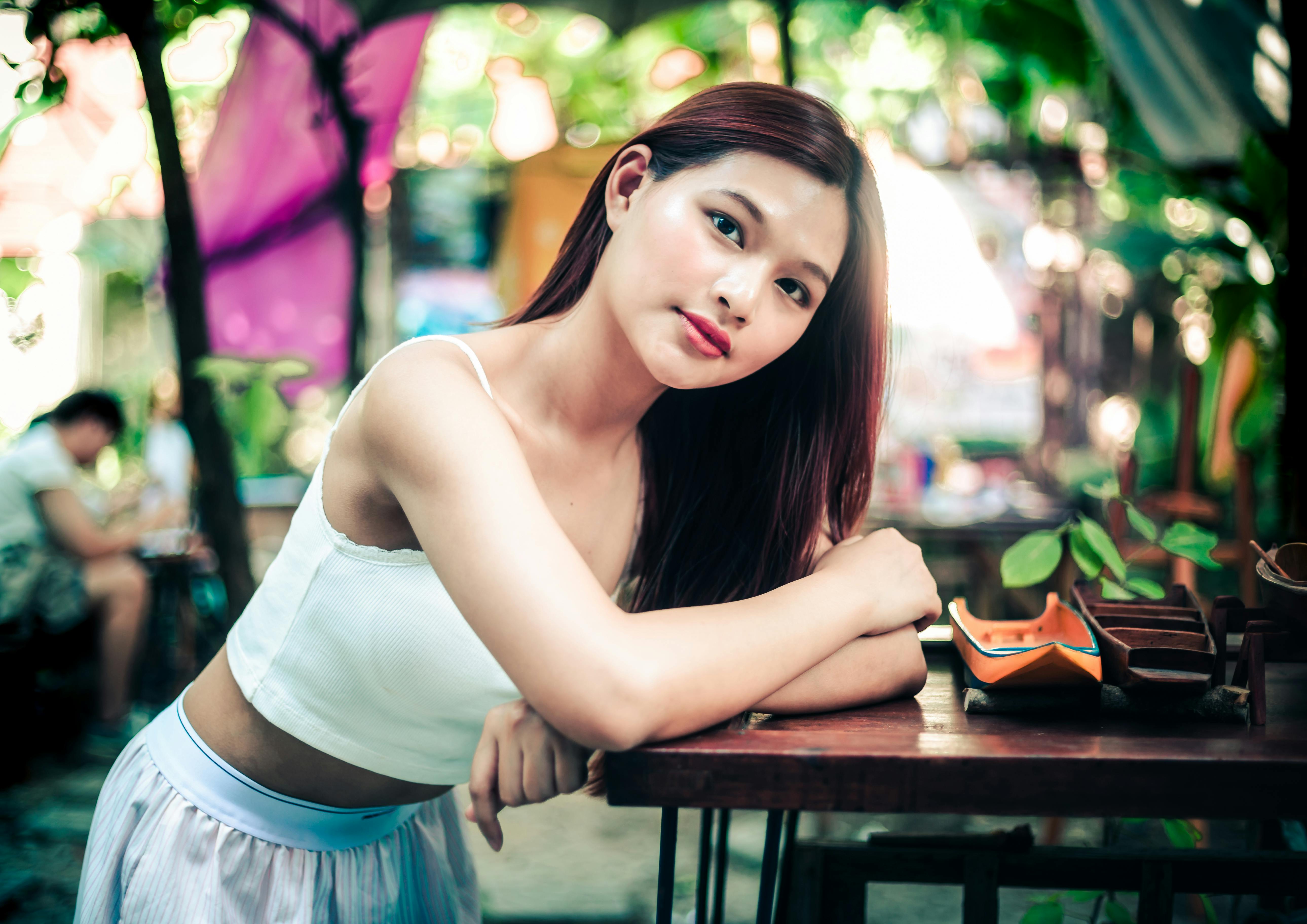 A serene outdoor portrait of a young woman relaxing in a garden setting.