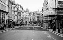 这张复古黑白照片拍摄了一条繁忙的城市街道，街上有历史悠久的建筑和行走的人们