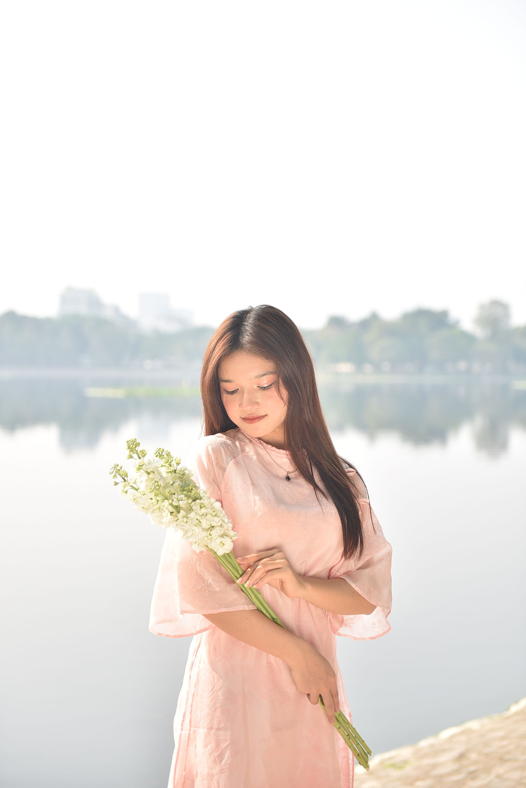 Young Woman in Pink Dress Holding Flowers by Lake · Free Stock Photo