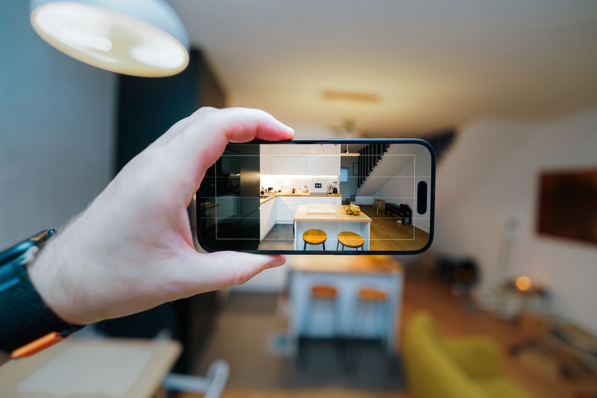 Smartphone photographing a modern kitchen for a property listing
