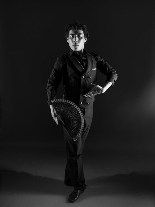 Free Black and white portrait of a male dancer in an elegant pose holding a fan. Stock Photo