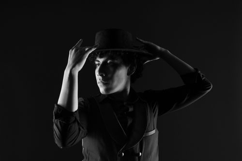Free A striking portrait of a male dancer in a hat. Black and white photograph with dramatic lighting. Stock Photo