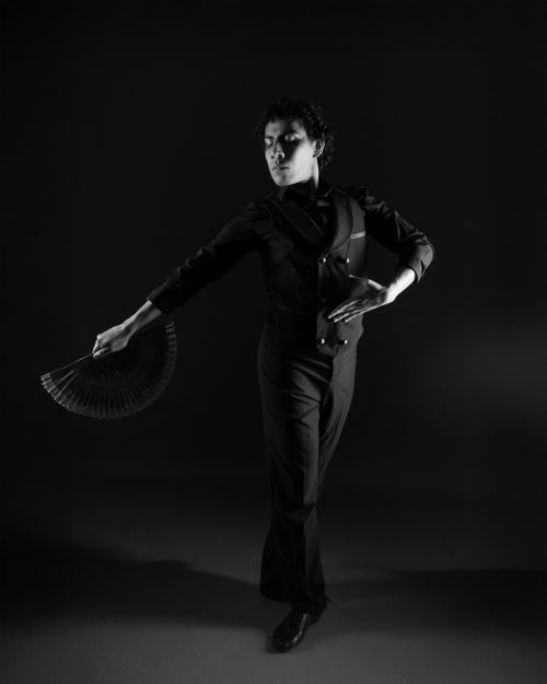 Free Black and white portrait of a male dancer with a fan, showcasing elegance and movement. Stock Photo