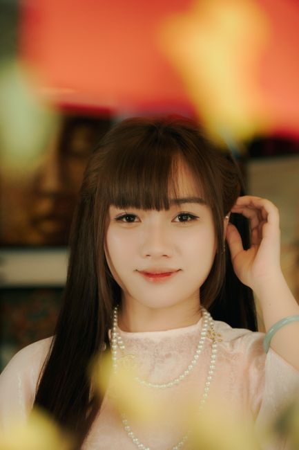 Charming portrait of a young woman in traditional attire, softly lit.