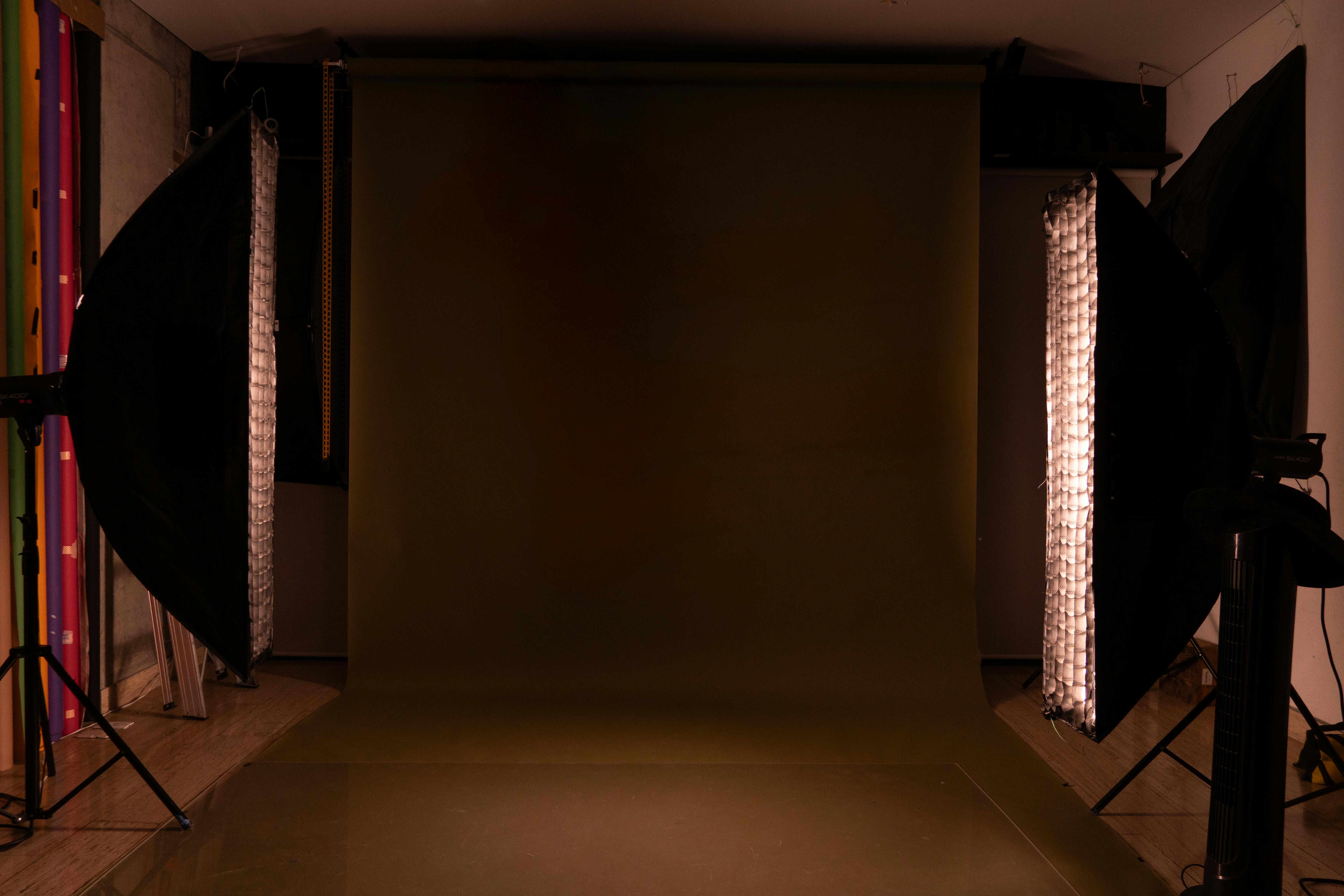 A sleek and modern photography studio setup featuring a mocha backdrop and professional lighting equipment.