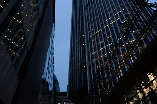 Free Low-angle shot of modern skyscrapers in a city at dusk with lights illuminating the glass facades. Stock Photo