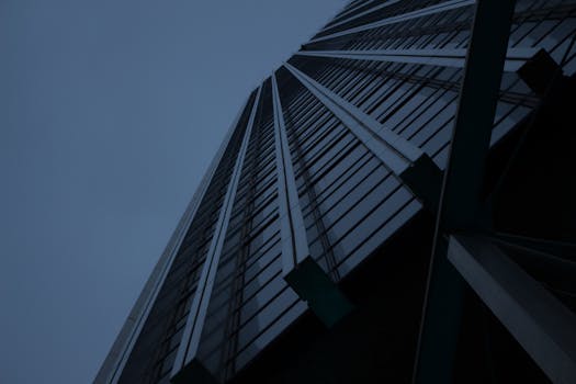 黄昏时分，从低角度拍摄的现代玻璃立面摩天大楼