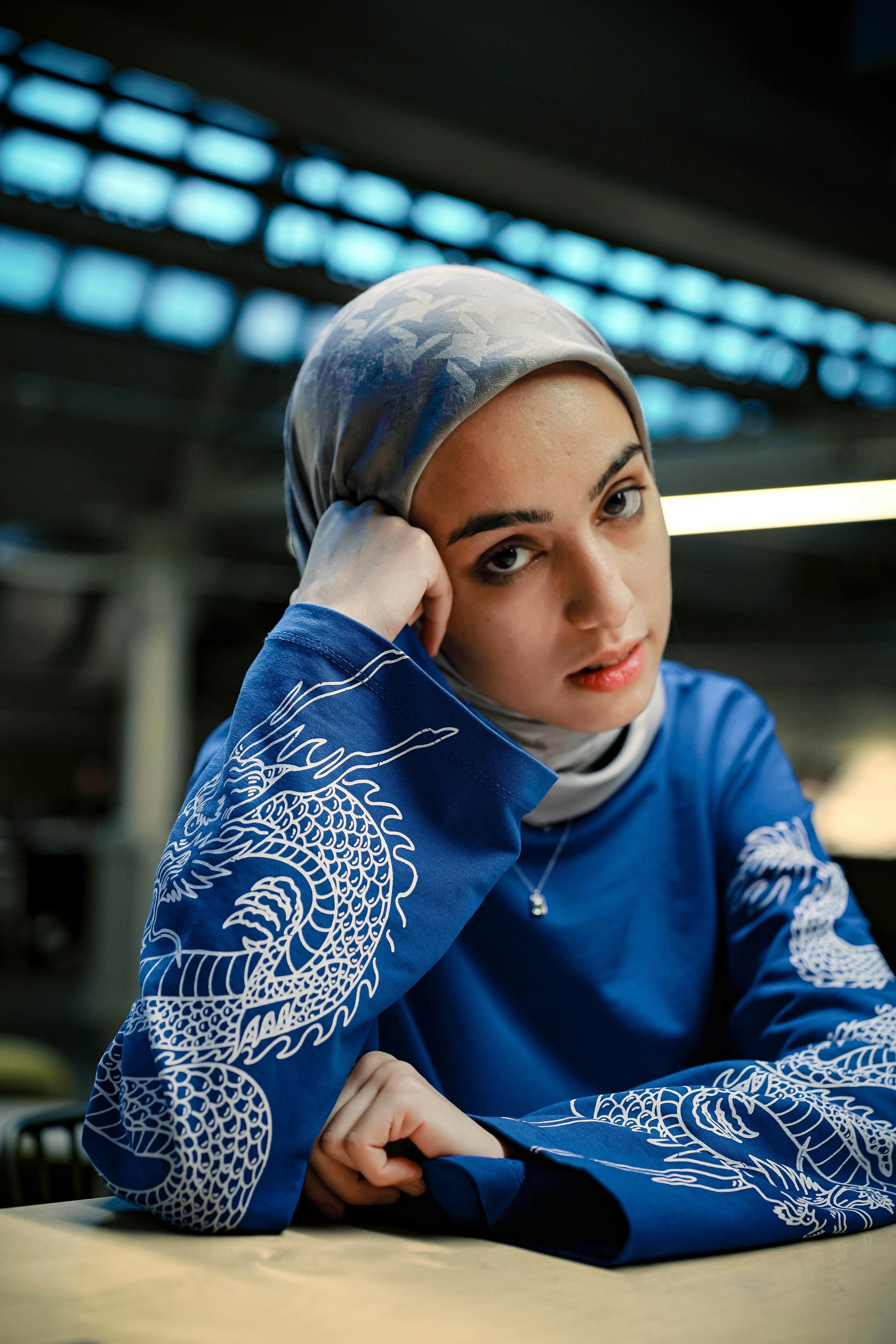Young Woman in Blue Hijab with Dragon Design · Free Stock Photo