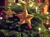 圣诞树上挂着闪闪发光的金星装饰品特写，灯光营造出节日的节日气氛