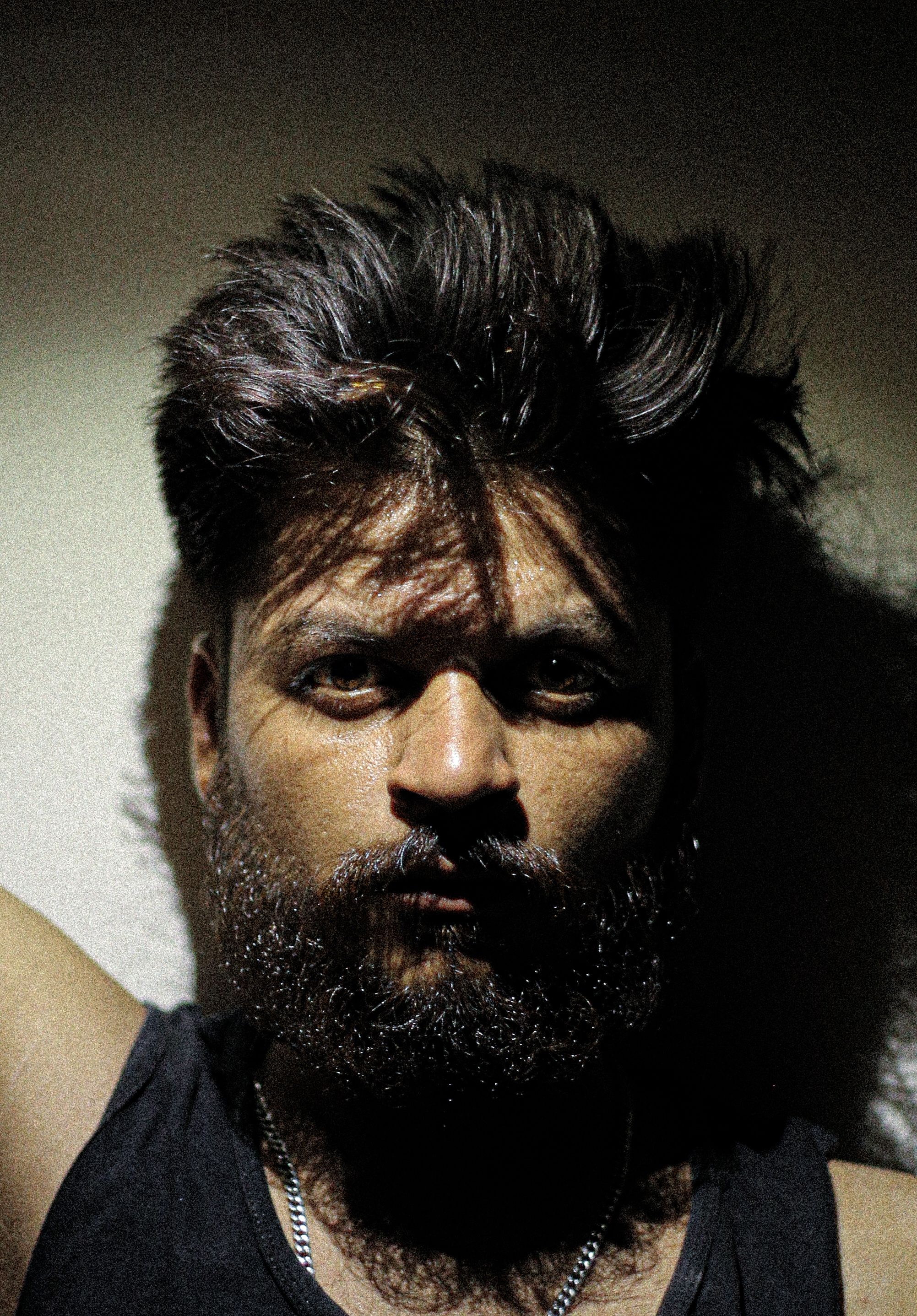 A moody portrait of a bearded man with dramatic lighting and shadows. Perfect for expressive art projects.