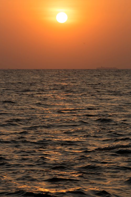 Free Stunning sunset reflecting on the ocean, creating a serene and warm atmosphere. Stock Photo