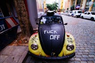 一辆涂满涂鸦的经典大众甲壳虫停在城市街道的鹅卵石路面上