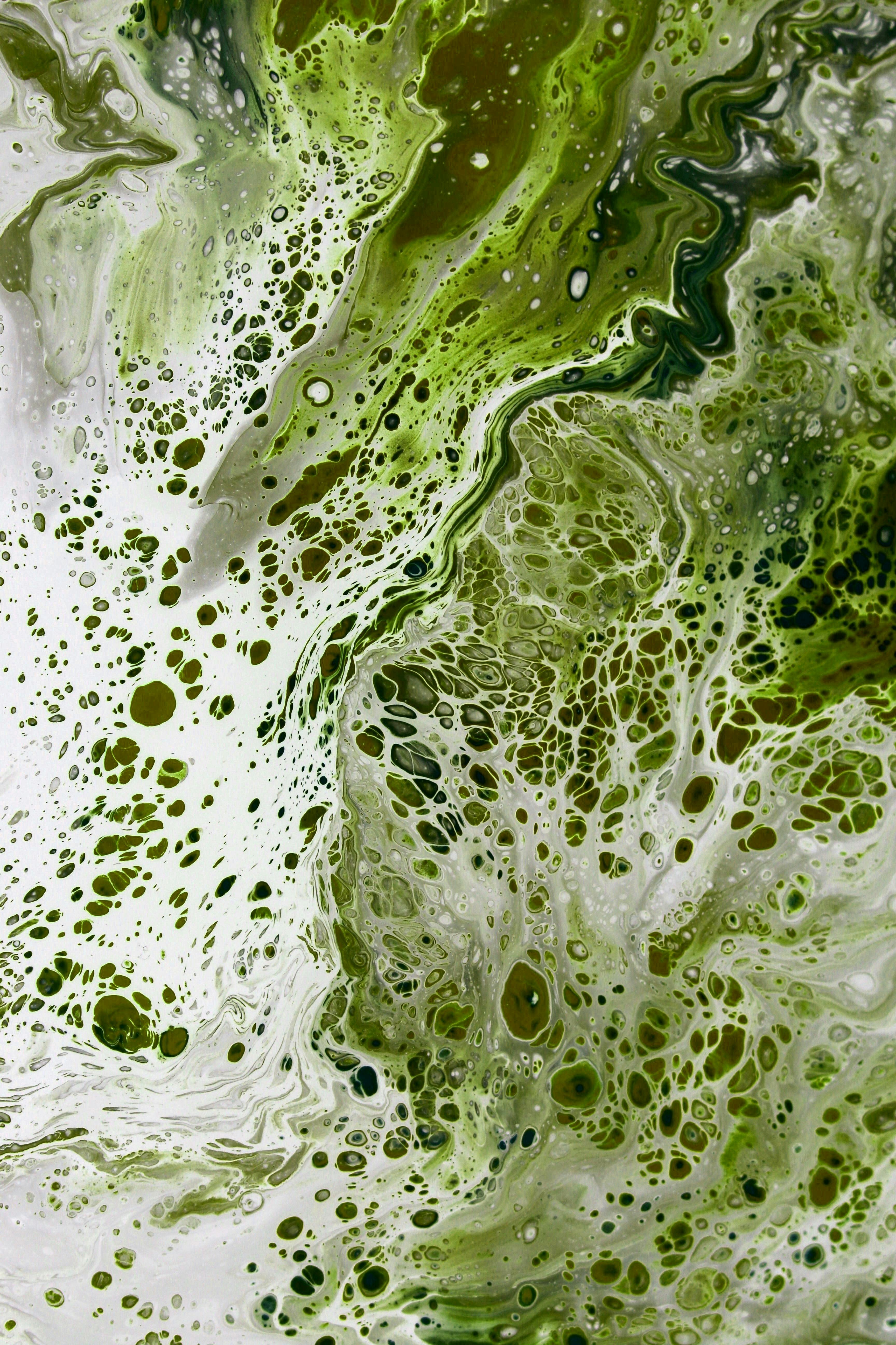 Dynamic green and white abstract paint swirl with cellular patterns.