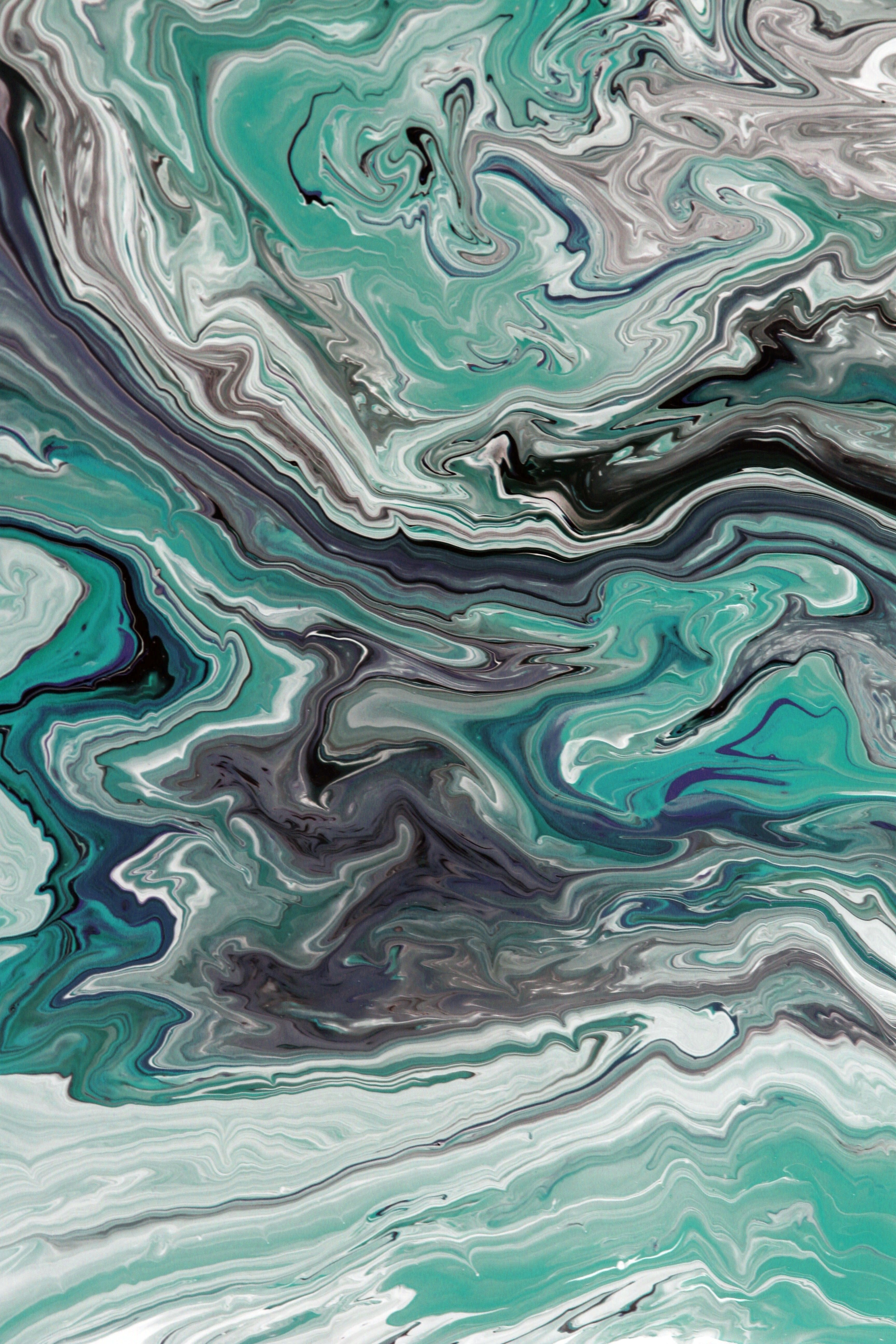 Dynamic abstract marble texture with teal and black swirls, perfect for modern art and design projects.