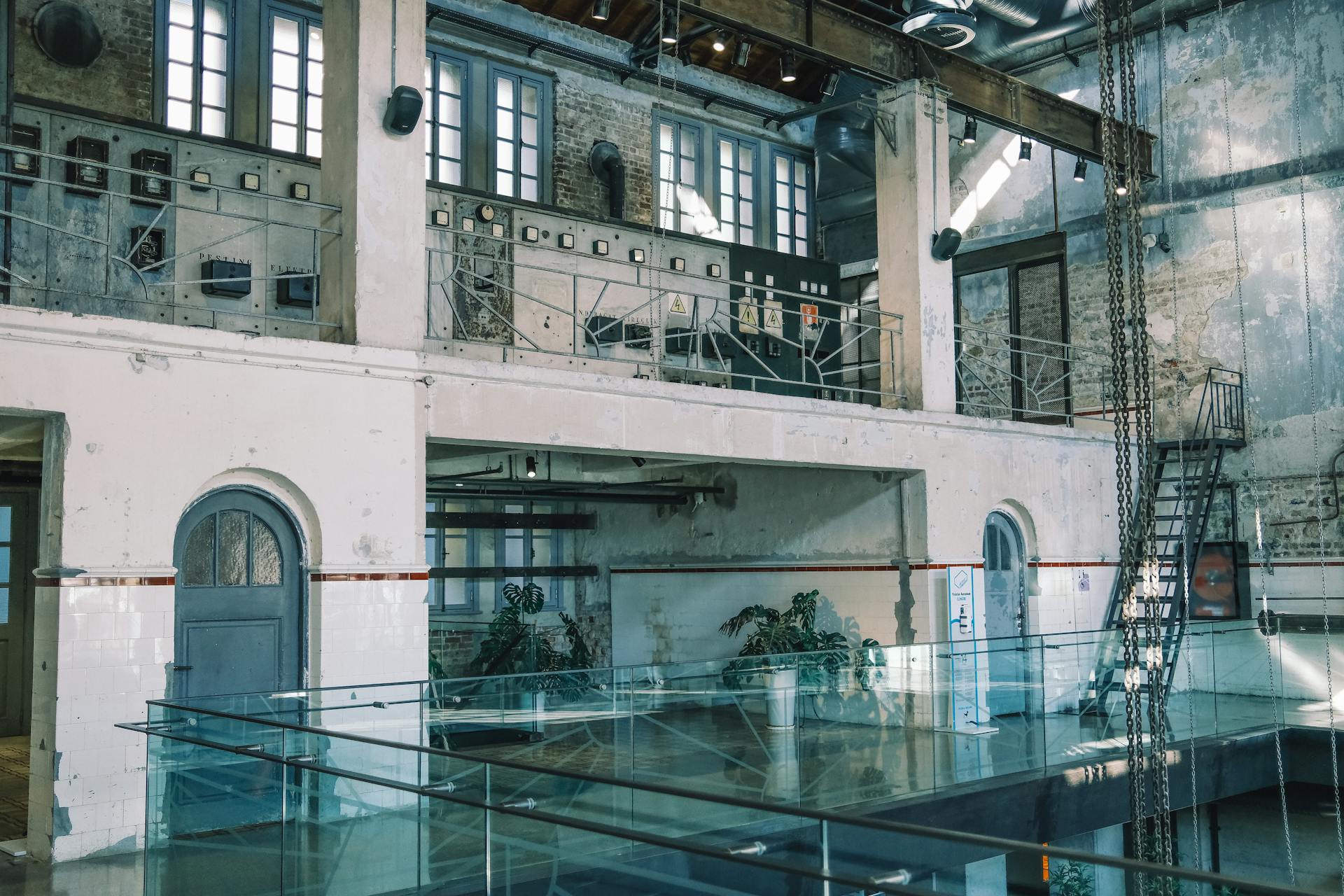 Rustic interior of an abandoned industrial building with exposed brick and metal elements.