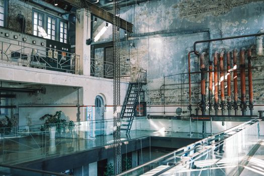 A vintage industrial interior with exposed pipes, brick walls, and metal staircases, captured in natural light.. pexels, vint