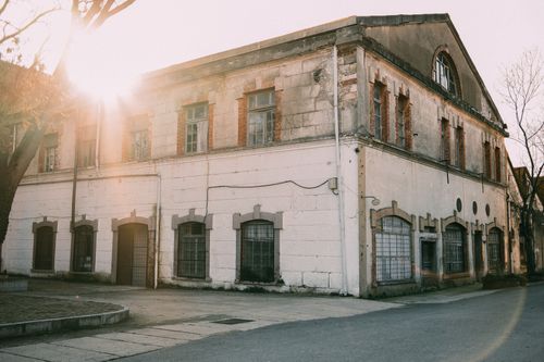 Free Sunlit facade of an old stone building exuding rustic charm at sunset. Stock Photo