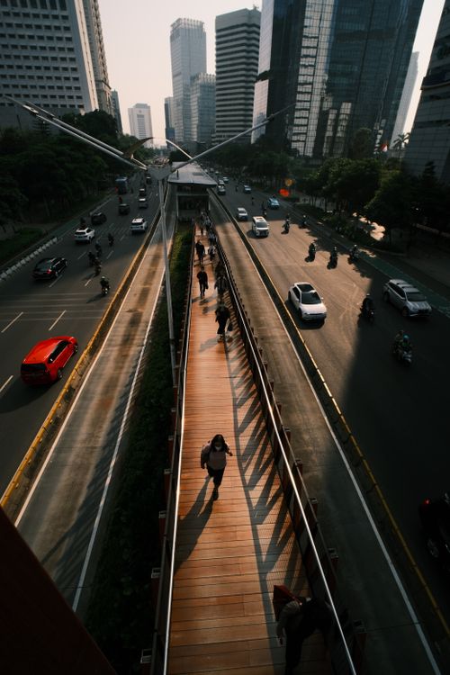 Free Commuters on an elevated pedestrian bridge in Jakarta, Indonesia, during a warm summer evening. Stock Photo