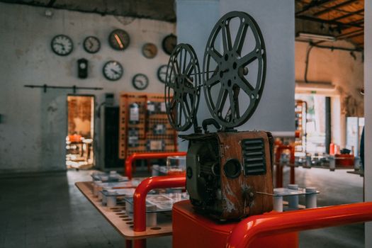 Rustic vintage film projector in an industrial-themed room with wall clocks. - Fotografer Sidoarjo