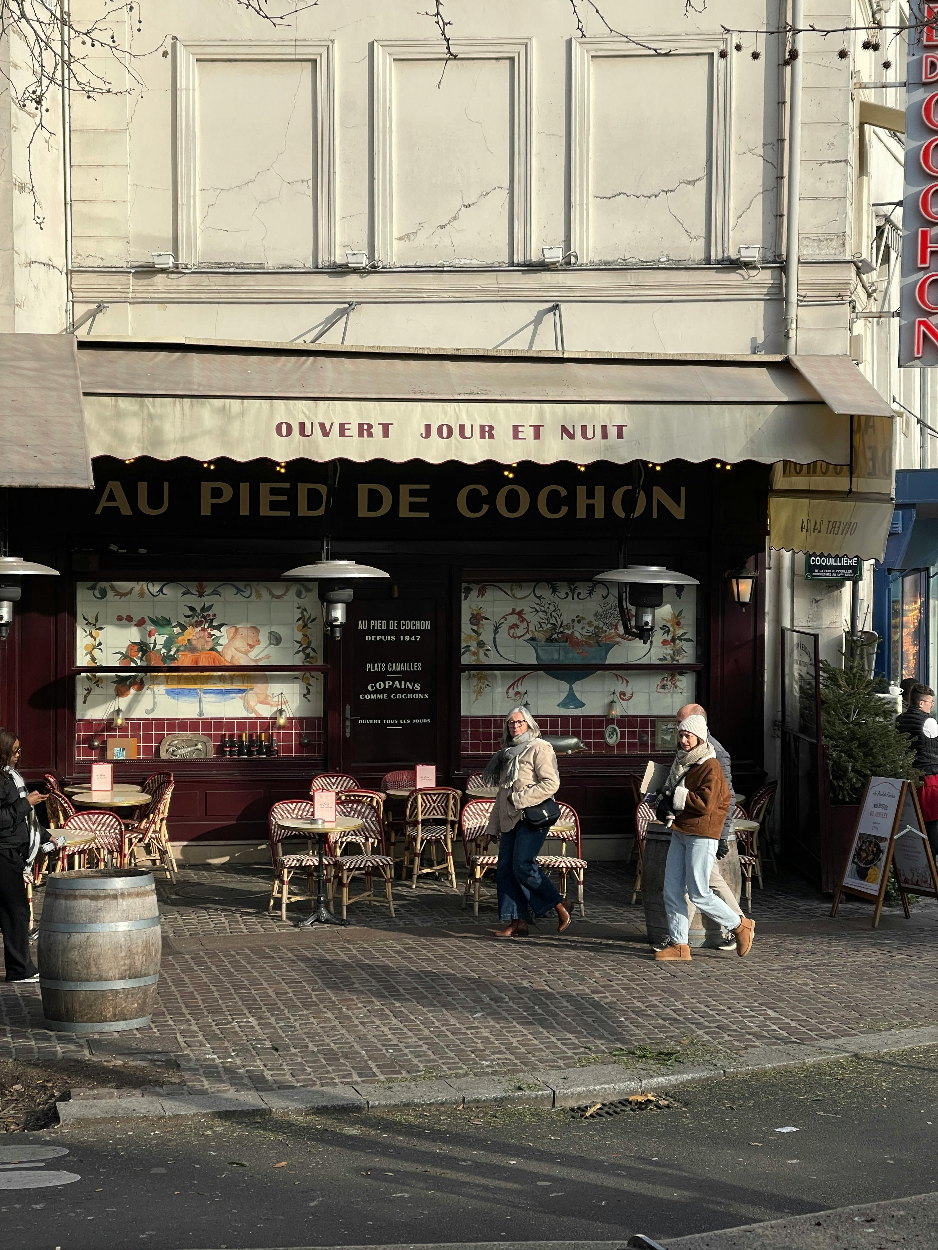 A bustling Parisian street scene showcasing the iconic Au Pied de Cochon café.
