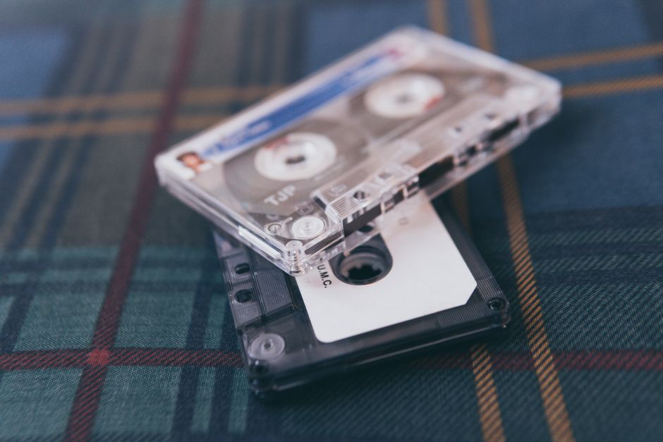 Close-up of retro cassette tapes on plaid fabric, evoking nostalgia and vintage vibes.